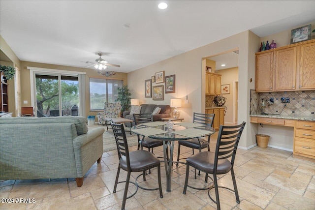 dining room featuring built in desk and ceiling fan