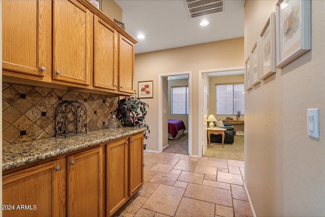 kitchen with light stone counters and backsplash