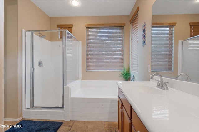 bathroom with vanity, a healthy amount of sunlight, and separate shower and tub