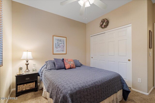 bedroom with ceiling fan, a closet, and light carpet