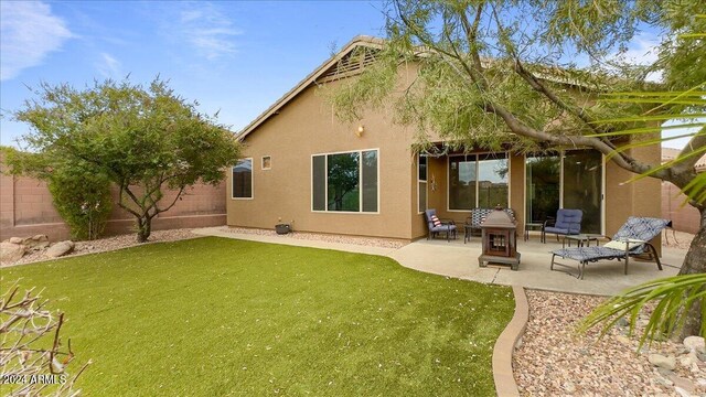 rear view of house featuring a lawn and a patio area