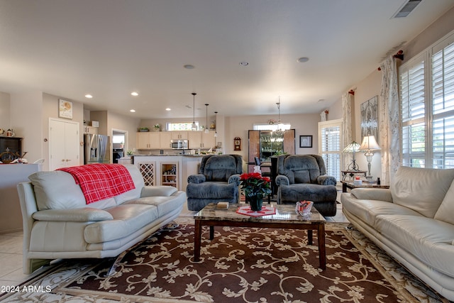 living room with light tile patterned flooring and a notable chandelier