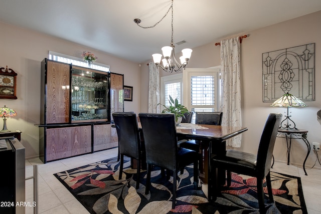 tiled dining space featuring an inviting chandelier