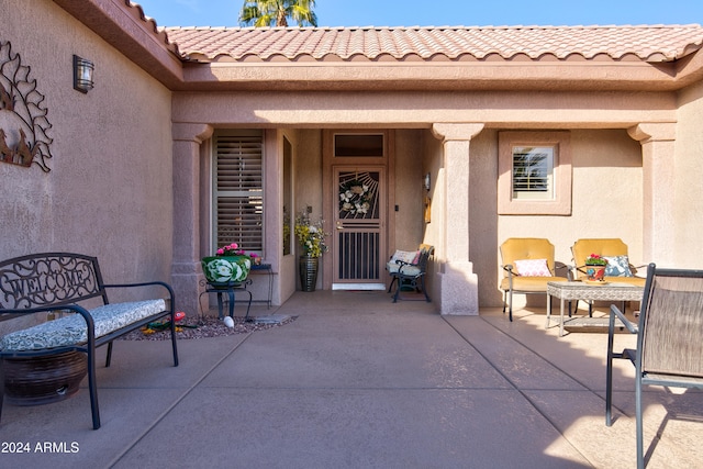 view of exterior entry with a patio