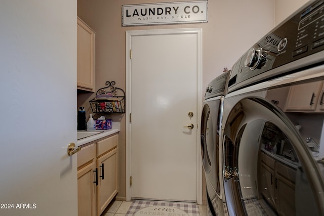 clothes washing area featuring light tile patterned flooring, cabinets, and separate washer and dryer