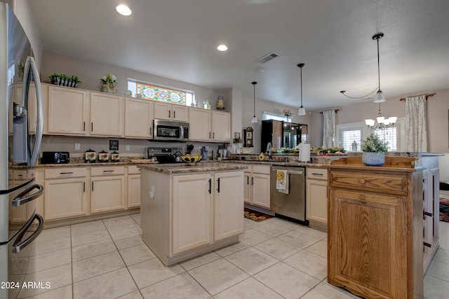 kitchen featuring a center island, an inviting chandelier, hanging light fixtures, appliances with stainless steel finishes, and kitchen peninsula