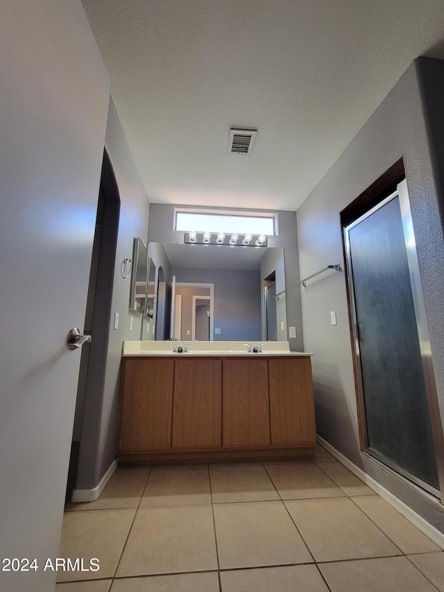 bathroom with a textured ceiling, vanity, and tile patterned floors