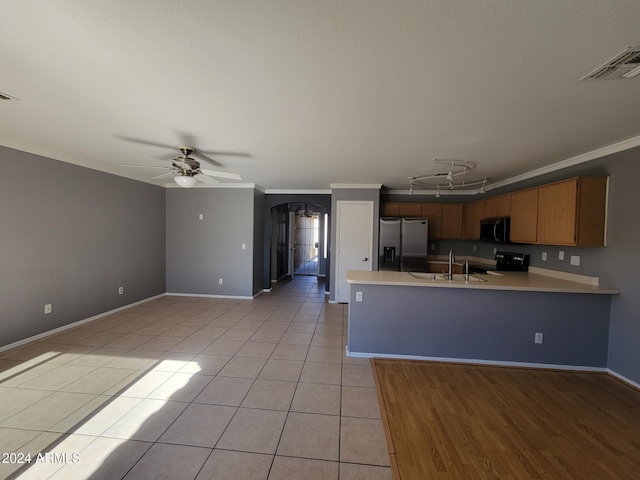 kitchen featuring crown molding, light tile patterned floors, arched walkways, and appliances with stainless steel finishes