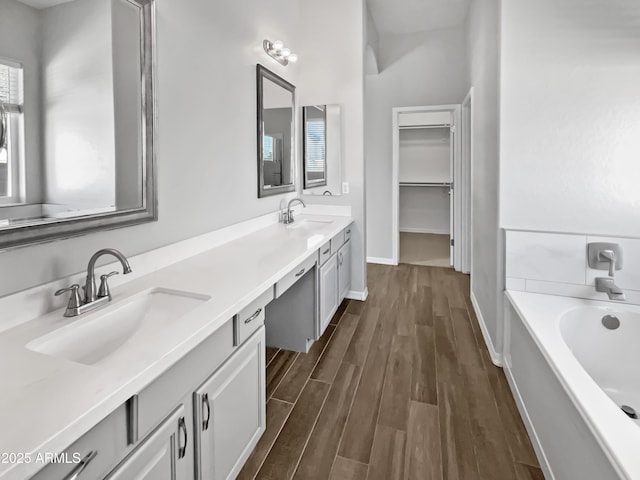 bathroom featuring a tub to relax in, hardwood / wood-style floors, and vanity