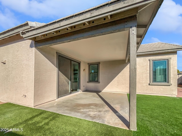 back of house with a patio area and a lawn