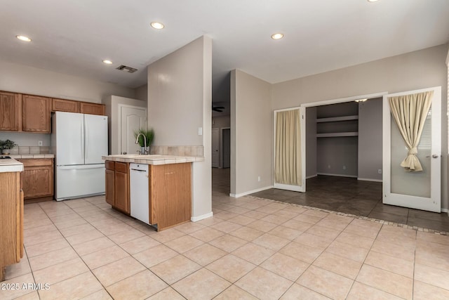 9511 E Kiva Ave, Mesa, AZ 85209 - kitchen featuring white appliances, tile countertops, light tile patterned floors, brown cabinets, and recessed lighting