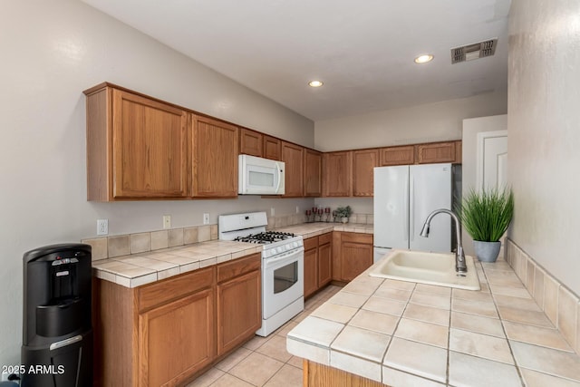 9511 E Kiva Ave, Mesa, AZ 85209 - kitchen featuring white appliances, tile counters, a sink, recessed lighting, and brown cabinetry