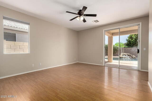 9511 E Kiva Ave, Mesa, AZ 85209 - unfurnished room with wood finished floors, ceiling fan, and baseboards