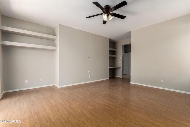 9511 E Kiva Ave, Mesa, AZ 85209 - empty room with a ceiling fan, wood finished floors, baseboards, and built in shelves