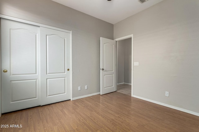 9511 E Kiva Ave, Mesa, AZ 85209 - unfurnished bedroom with wood finished floors, baseboards, and a closet