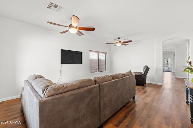 living room with ceiling fan and dark wood-type flooring