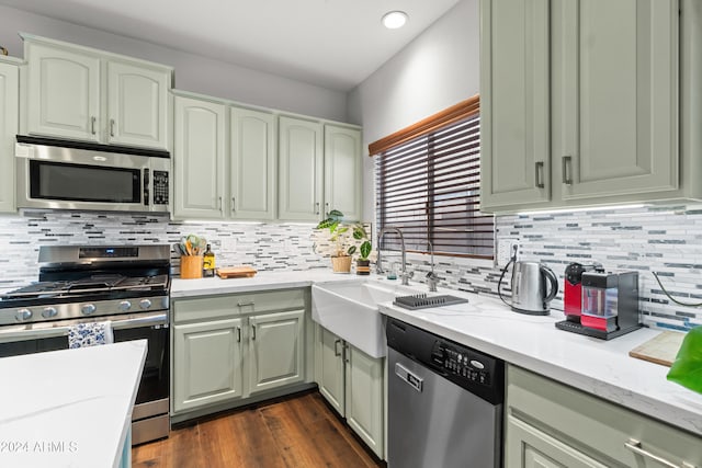 kitchen featuring appliances with stainless steel finishes, backsplash, dark hardwood / wood-style floors, and sink