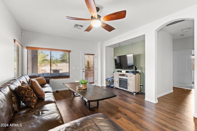 living room featuring ceiling fan and dark hardwood / wood-style flooring