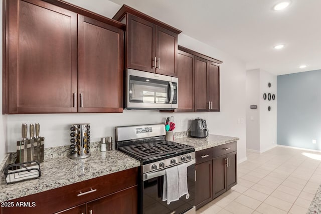 kitchen with light stone countertops, appliances with stainless steel finishes, and light tile patterned floors