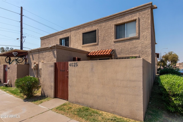 view of front of property featuring stucco siding, a fenced front yard, and a gate