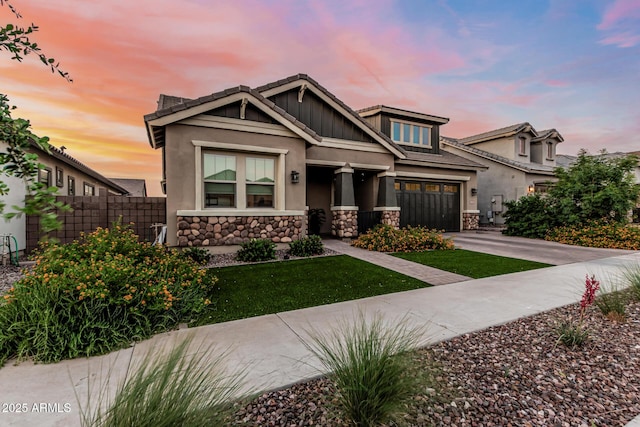 view of front facade featuring stone siding, concrete driveway, and stucco siding