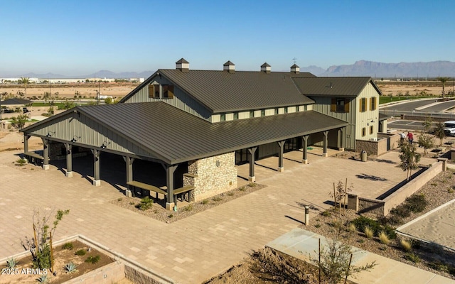 back of property featuring a mountain view, a standing seam roof, and metal roof