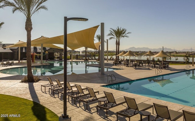 community pool with a patio area and a mountain view