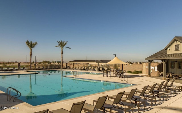 community pool featuring fence and a patio area