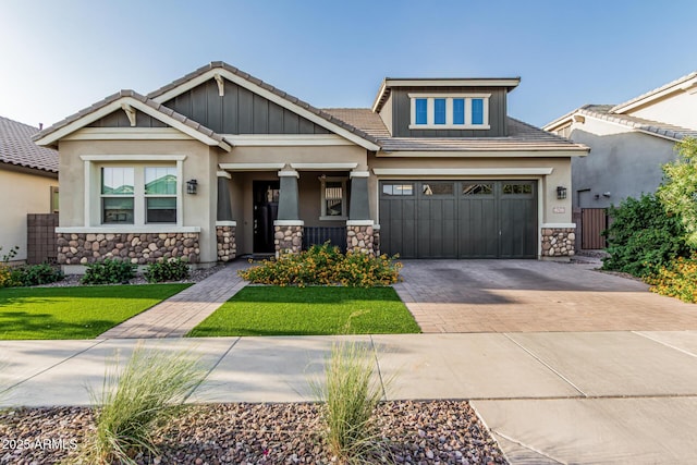 craftsman-style house featuring stone siding, decorative driveway, stucco siding, and a tile roof
