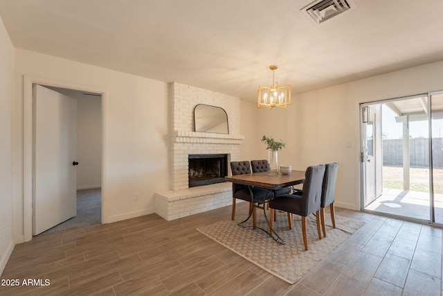 3118 S Los Altos Dr, Mesa, AZ 85202 - dining space featuring wood finished floors, a chandelier, baseboards, and a fireplace