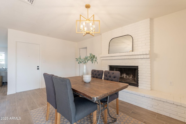 3118 S Los Altos Dr, Mesa, AZ 85202 - dining area with wood tiled floors, a chandelier, and a brick fireplace