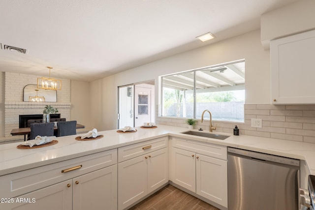 3118 S Los Altos Dr, Mesa, AZ 85202 - kitchen featuring dishwasher, a sink, a fireplace, backsplash, and white cabinetry