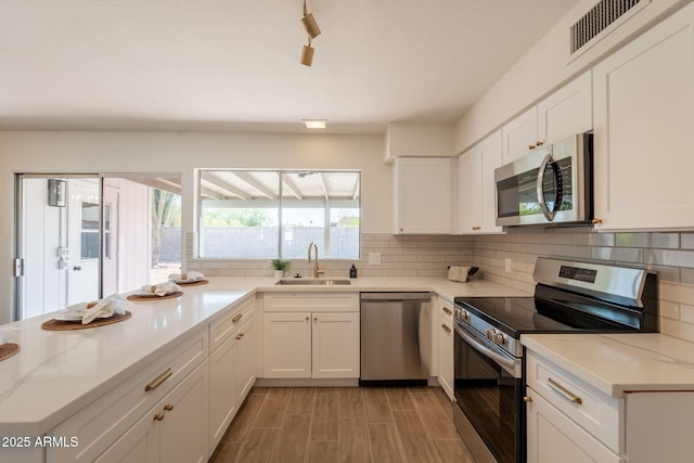 3118 S Los Altos Dr, Mesa, AZ 85202 - kitchen with appliances with stainless steel finishes, a sink, backsplash, and white cabinetry