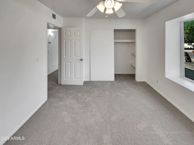 unfurnished bedroom with light carpet, a closet, and ceiling fan