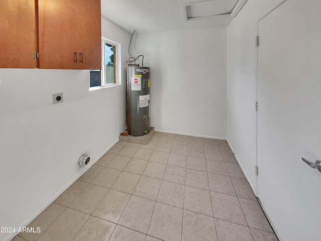 laundry area featuring electric dryer hookup, light tile patterned flooring, cabinets, and electric water heater