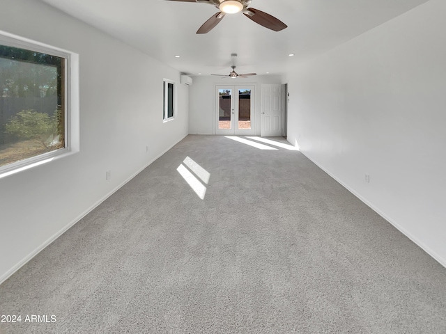 carpeted spare room with ceiling fan and french doors