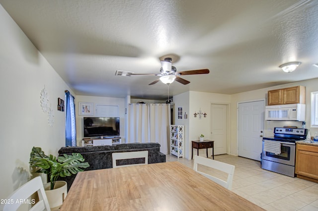 dining room with light tile patterned floors, a textured ceiling, and ceiling fan