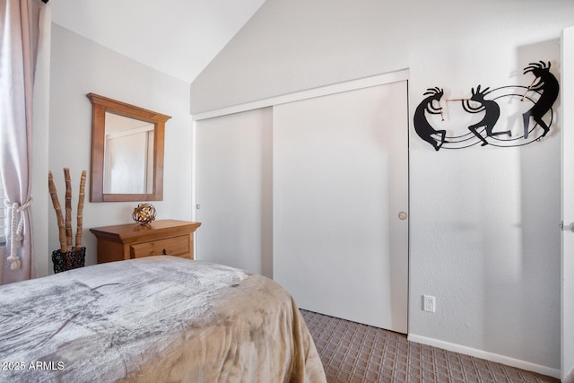 carpeted bedroom with lofted ceiling and a closet