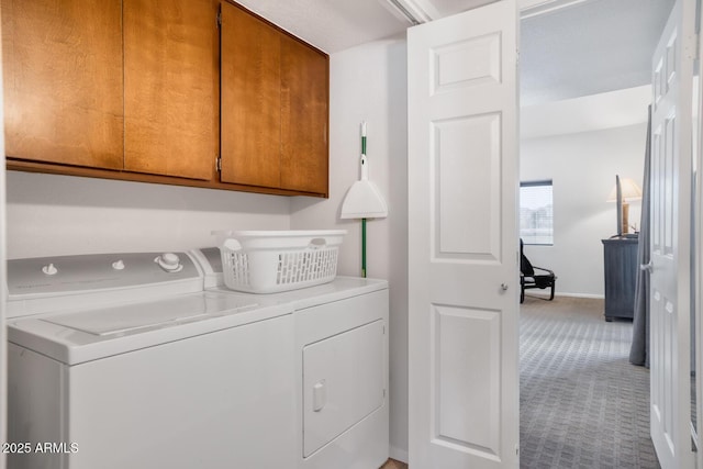 clothes washing area with cabinets, washing machine and dryer, and light colored carpet