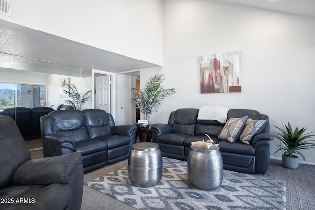 living room with a towering ceiling and carpet