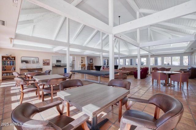 tiled dining room featuring high vaulted ceiling and beam ceiling