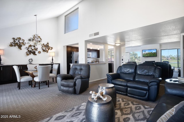 carpeted living room with high vaulted ceiling