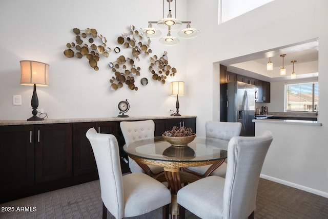 dining room with dark carpet and a raised ceiling