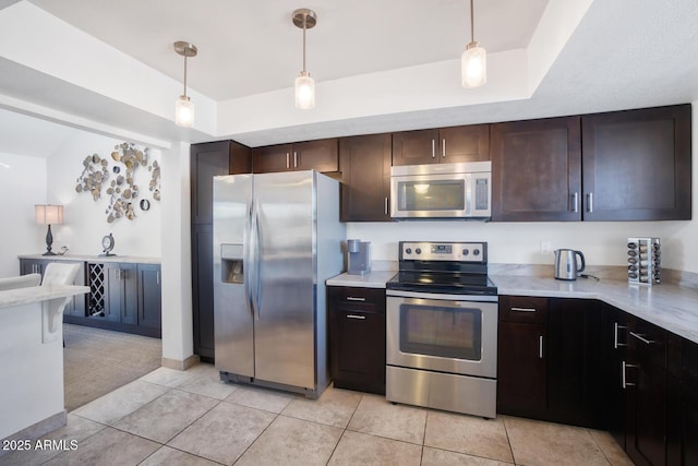 kitchen with hanging light fixtures, dark brown cabinets, a raised ceiling, and appliances with stainless steel finishes