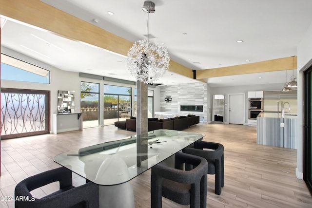 dining space with light hardwood / wood-style floors and an inviting chandelier