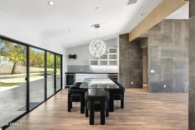 dining area with lofted ceiling, light wood-type flooring, an inviting chandelier, and beverage cooler