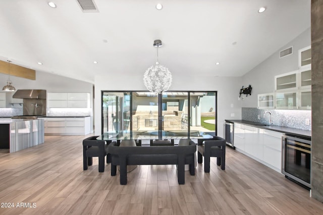 dining area with wine cooler, a healthy amount of sunlight, and vaulted ceiling