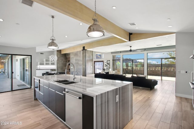 kitchen featuring a spacious island, stainless steel dishwasher, light hardwood / wood-style flooring, pendant lighting, and sink