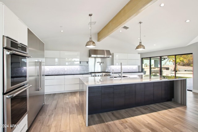 kitchen featuring white cabinetry, light hardwood / wood-style floors, wall chimney exhaust hood, and sink