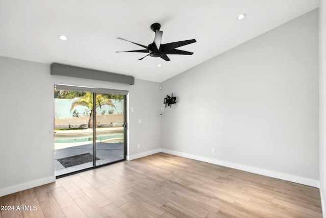 spare room with light hardwood / wood-style flooring, vaulted ceiling, and ceiling fan